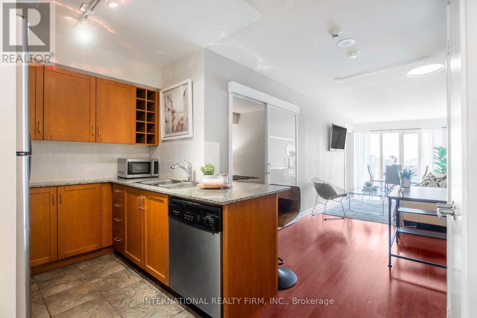 A kitchen with wooden cabinets and a stainless steel dishwasher.