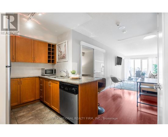 A kitchen with wooden cabinets and a stainless steel dishwasher.