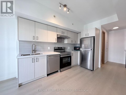 A modern kitchen with white cabinets and stainless steel appliances.