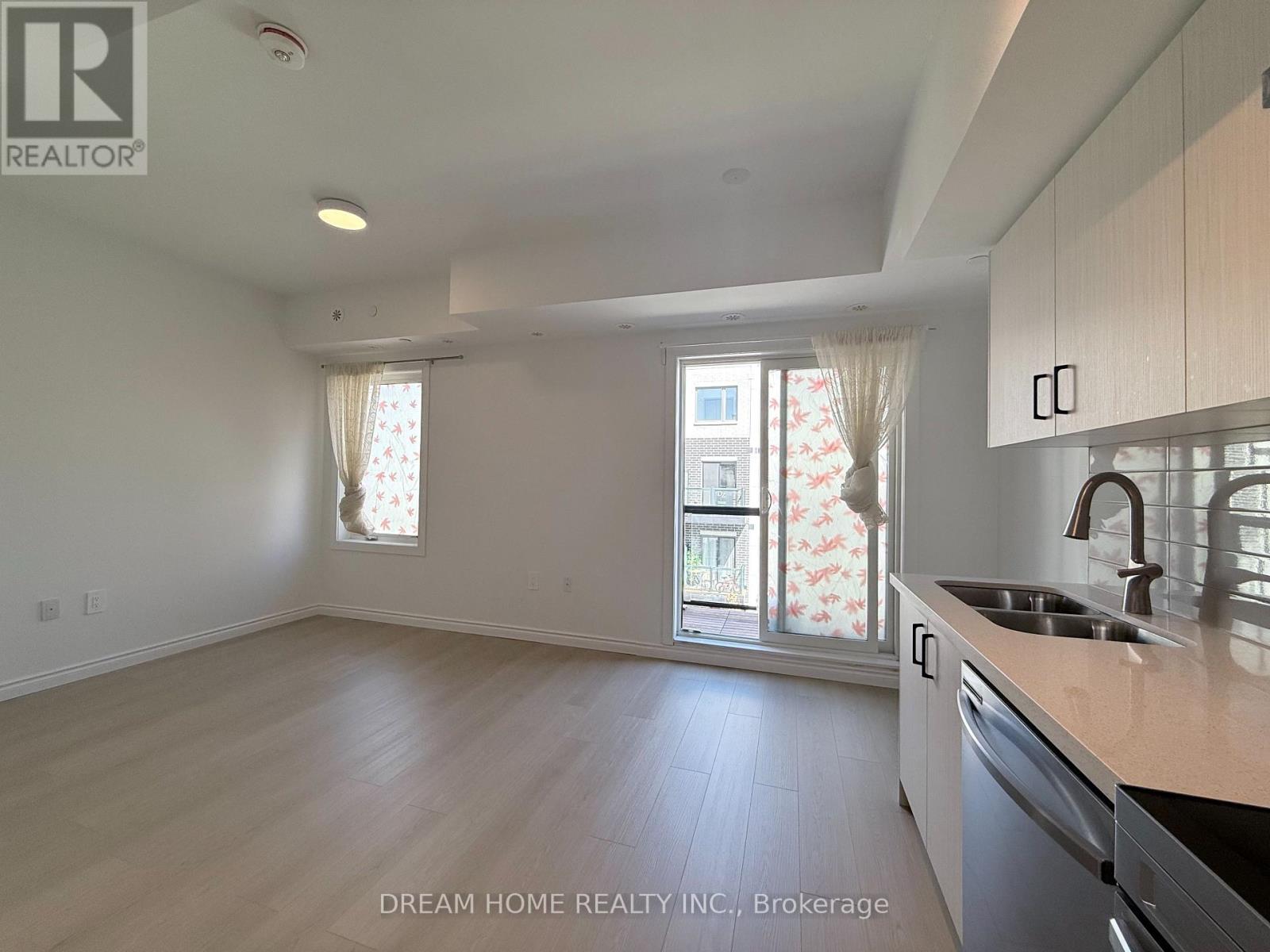 A kitchen with a sink, dishwasher, and cabinets.