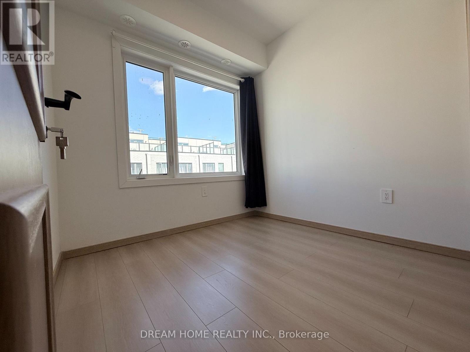 A room with a window and a wooden floor.