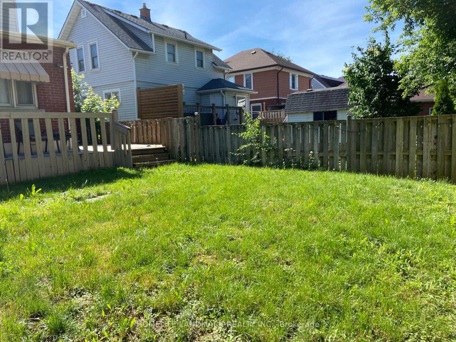 A backyard with a wooden fence and a grassy area.