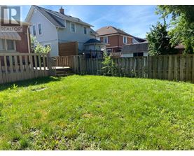 A backyard with a wooden fence and a grassy area.