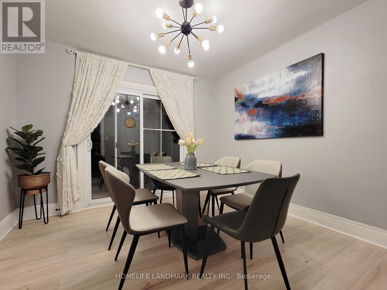 A dining room with a table set for two and a painting on the wall.