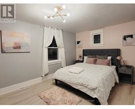 A bedroom with a large bed and a window with curtains.
