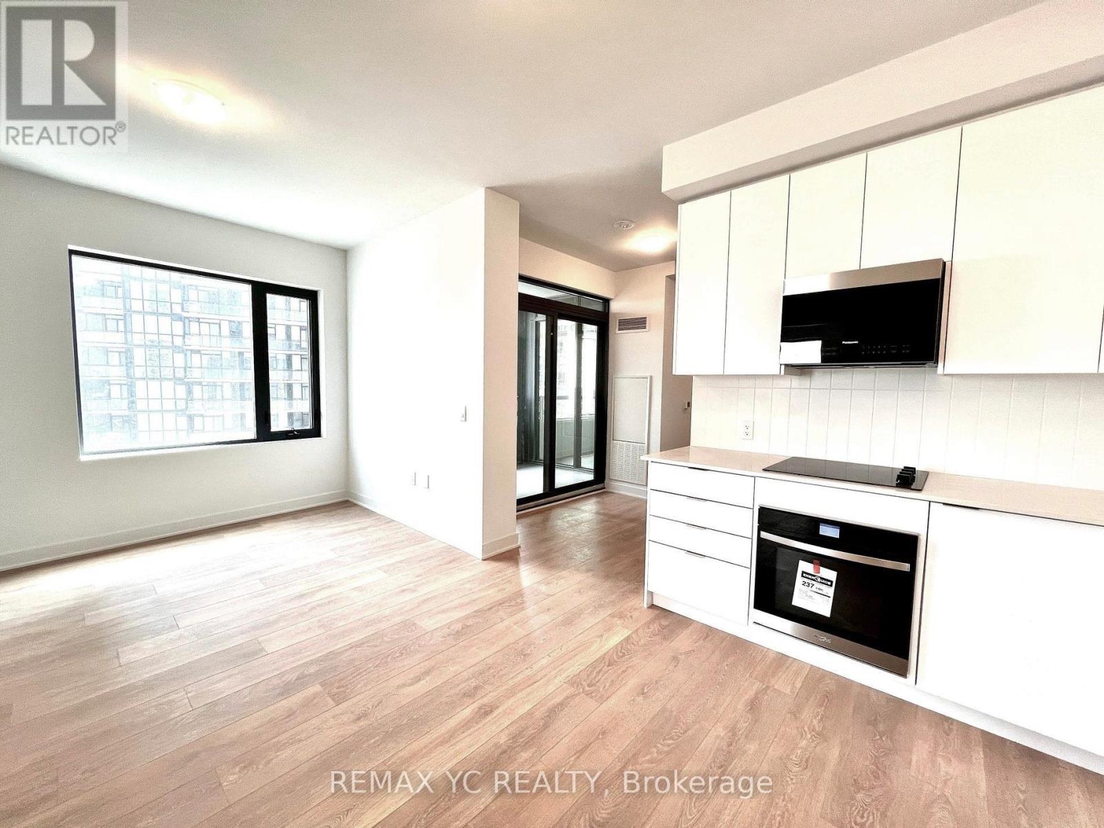 A kitchen with white cabinets and a black oven.