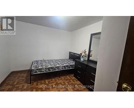A bedroom with a bed, dresser, and mirror.