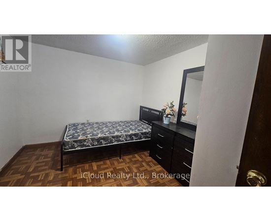 A bedroom with a bed, dresser, and mirror.