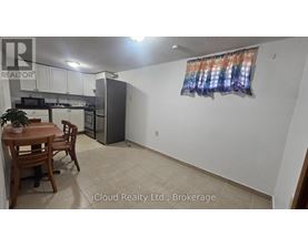 A kitchen with a table and chairs in the foreground and a refrigerator in the background.