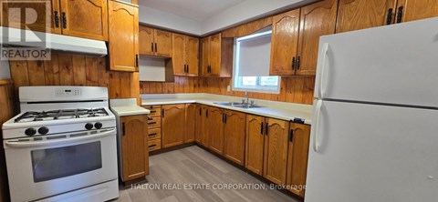 A kitchen with wooden cabinets and a white refrigerator.