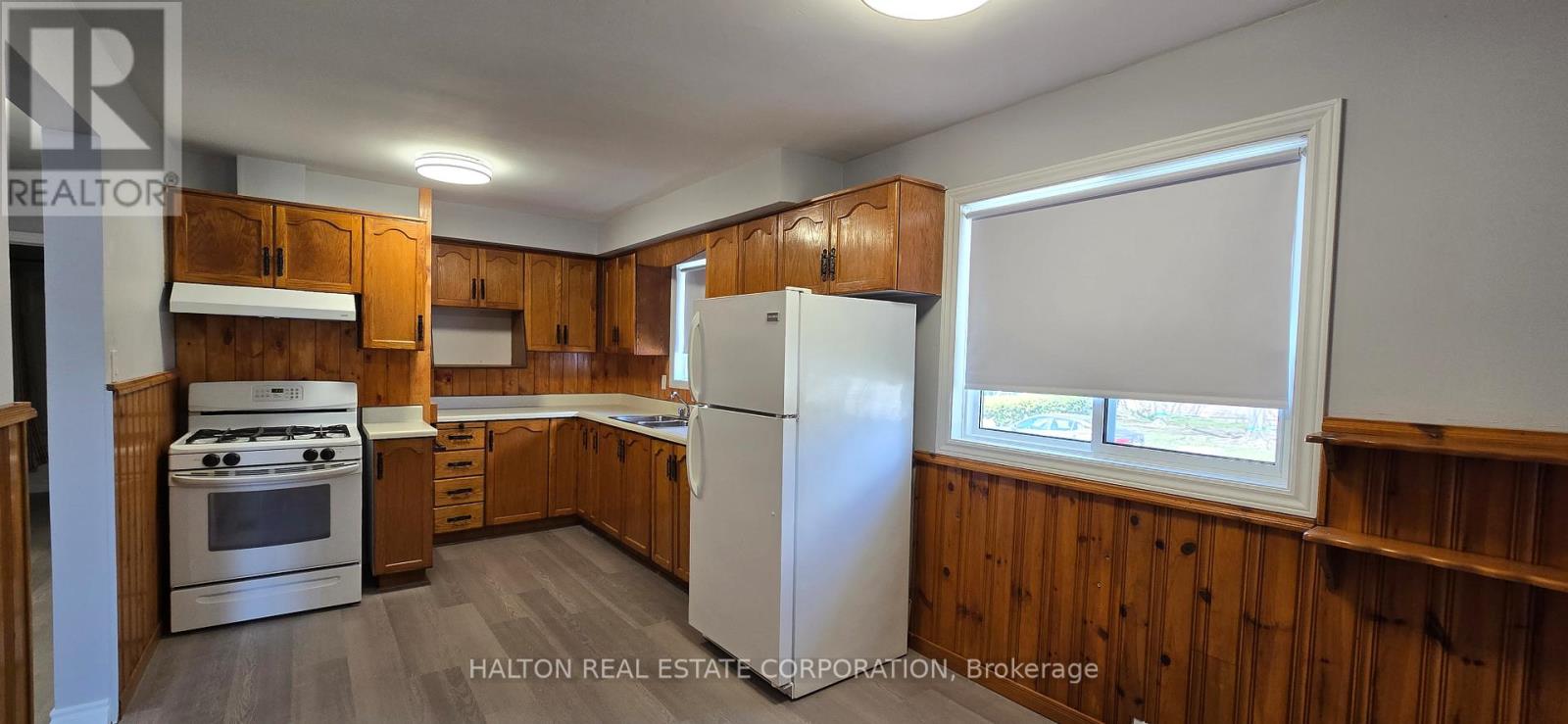 A kitchen with wooden cabinets and a white refrigerator.