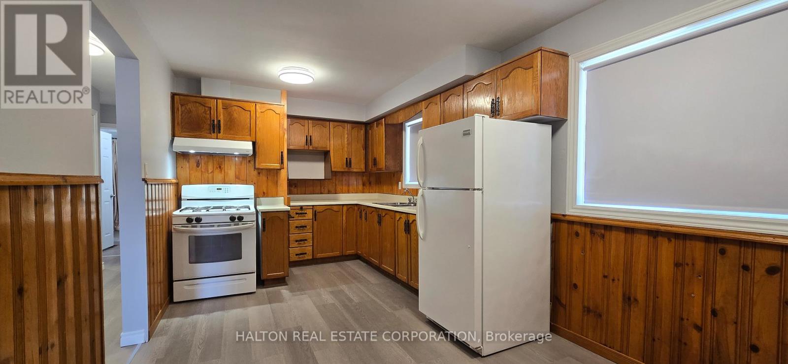 A kitchen with wooden cabinets and a white refrigerator.