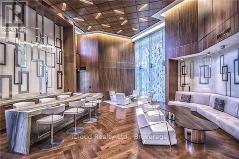 A modern living room with a long white couch and a long table with chairs.