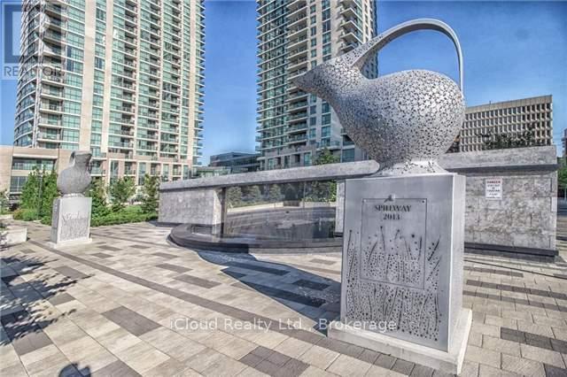 A large sculpture of a teapot is displayed in a public space.