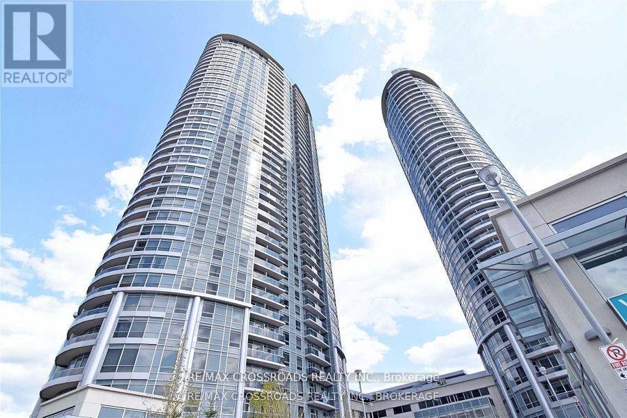 Two tall buildings with glass windows and a blue sky in the background.