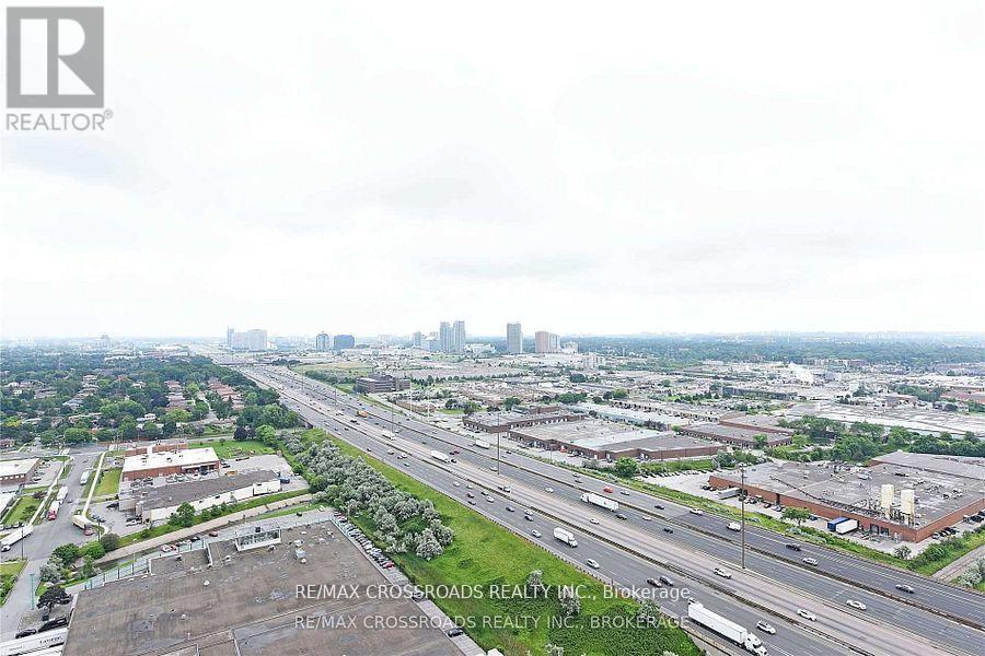 A cityscape with a highway and buildings, with the RE/MAX Crossroads Realty Inc. logo in the corner.