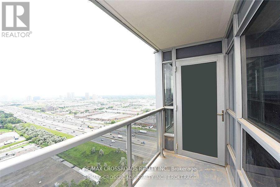 A balcony with a view of a highway and greenery.