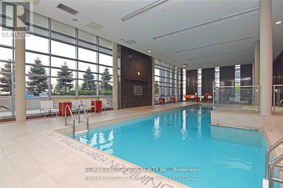 A large indoor swimming pool with a glass wall on one side.