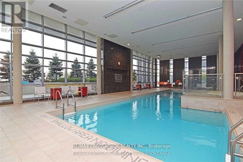 A large indoor swimming pool with a glass wall on one side.