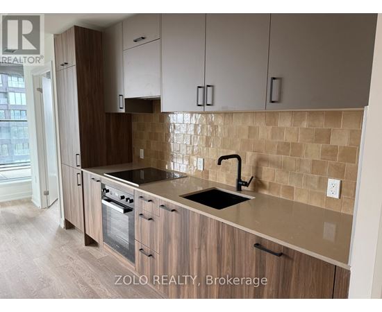 A kitchen with wooden cabinets and a tiled backsplash.
