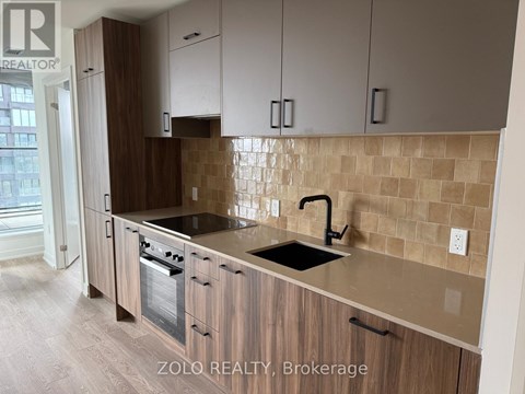 A kitchen with wooden cabinets and a tiled backsplash.