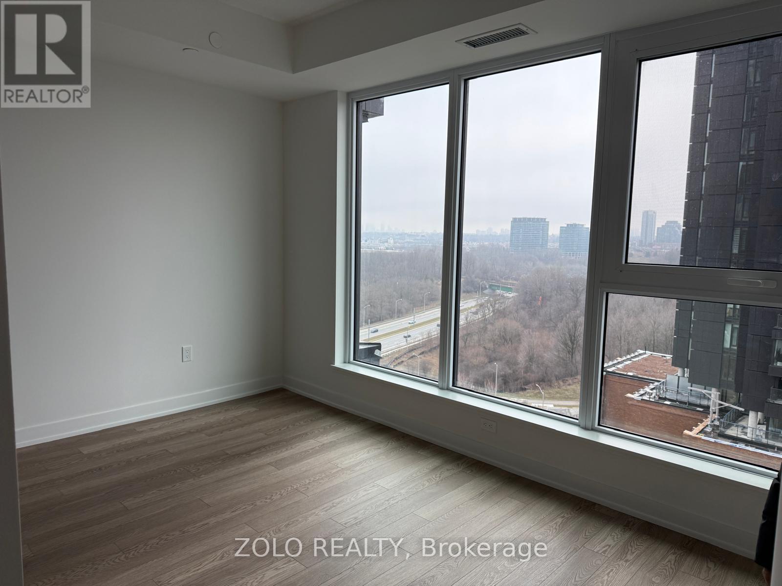 A room with a view of the cityscape through large windows.