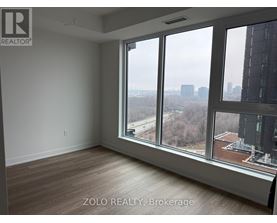 A room with a view of the cityscape through large windows.