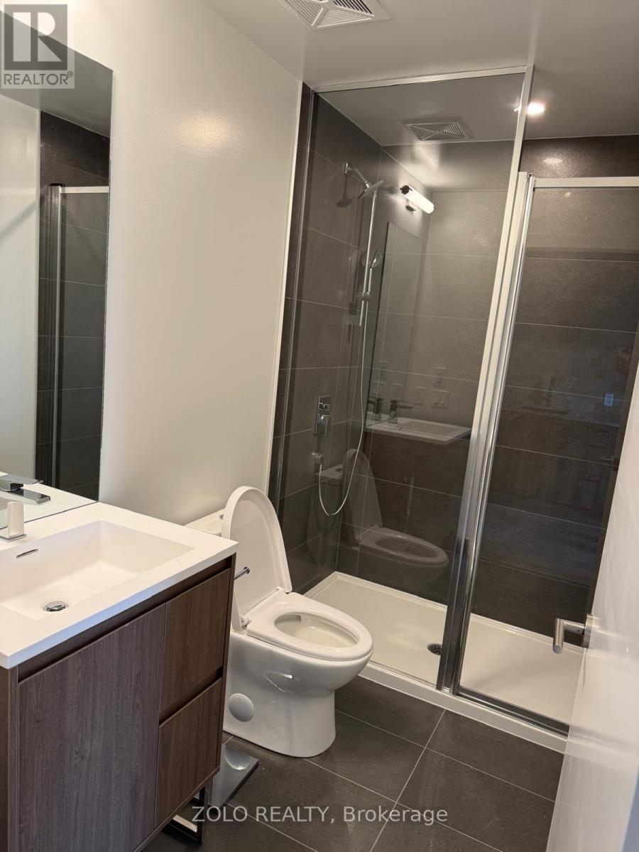 A bathroom with a toilet, sink, and shower.