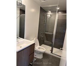 A bathroom with a toilet, sink, and shower.