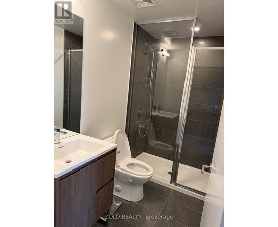 A bathroom with a toilet, sink, and shower.