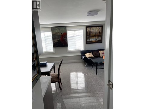 A living room with a couch, chair, and painting on the wall.