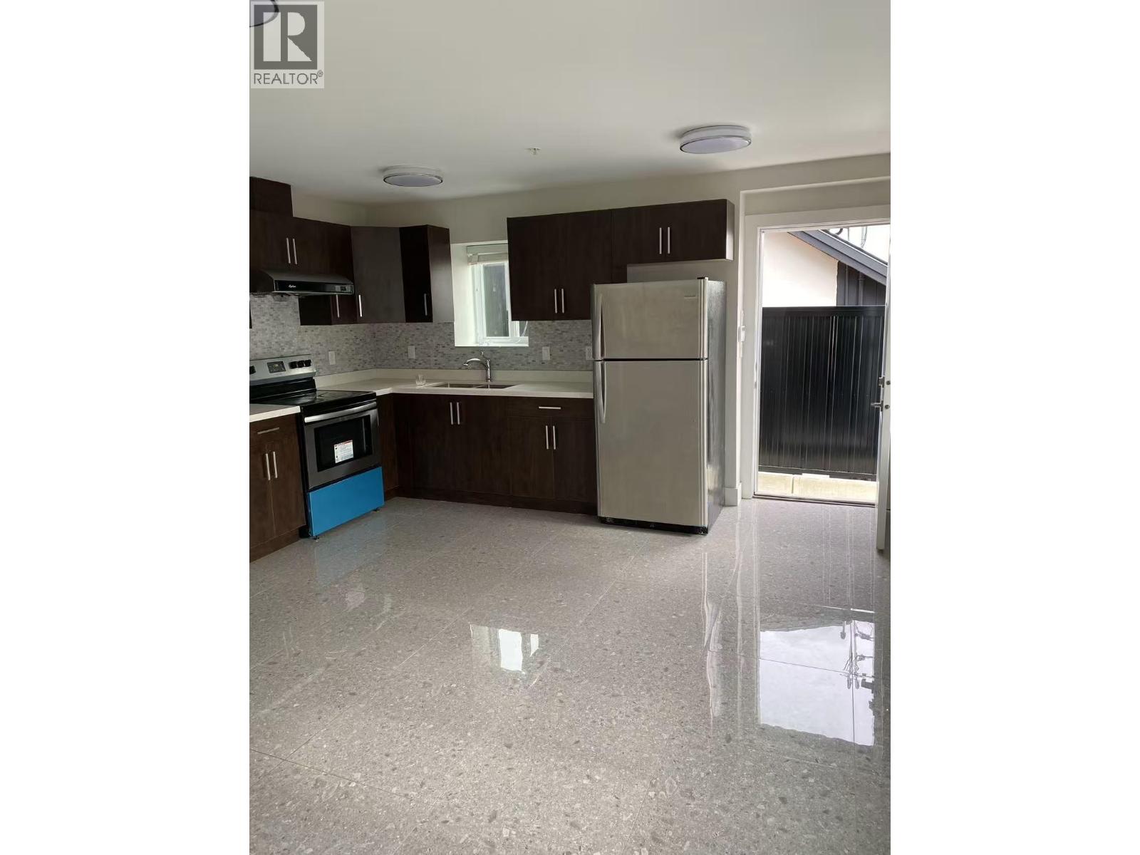 A kitchen with brown cabinets and a white fridge.