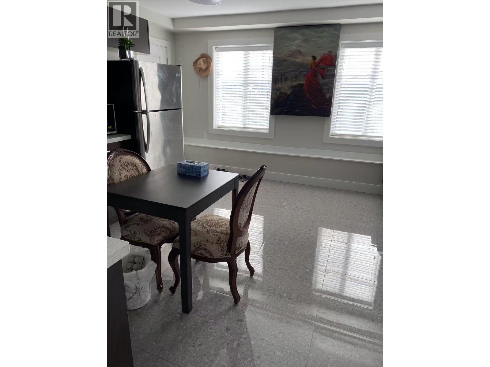 A dining room with a table and chairs.