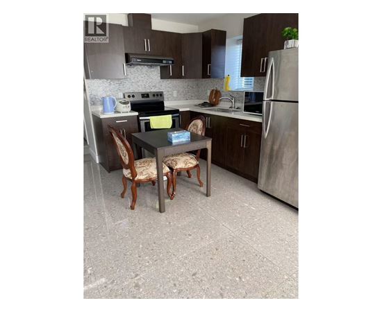 A kitchen with a table and chairs.