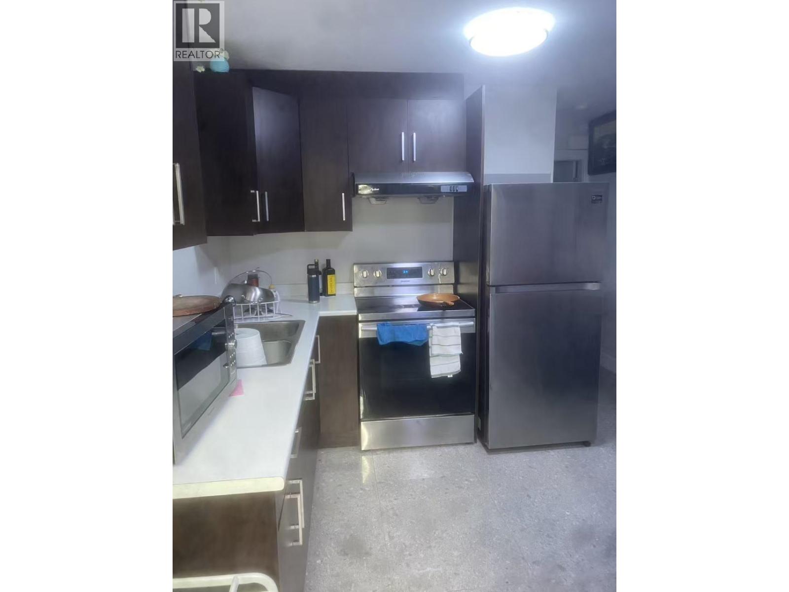 A kitchen with a sink, stove, and refrigerator.