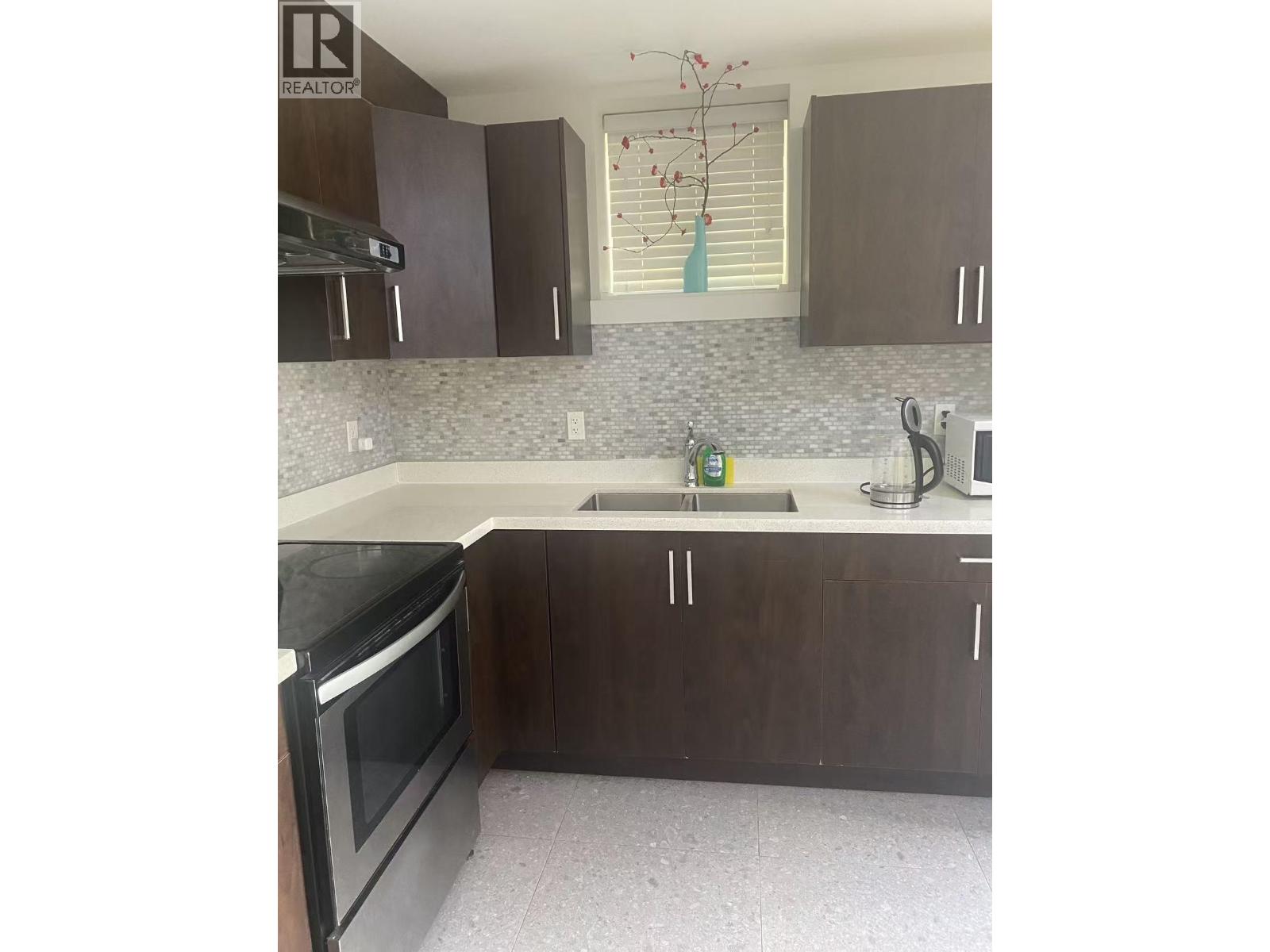 A kitchen with brown cabinets and a black oven.
