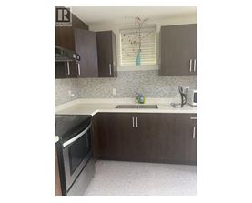 A kitchen with brown cabinets and a black oven.
