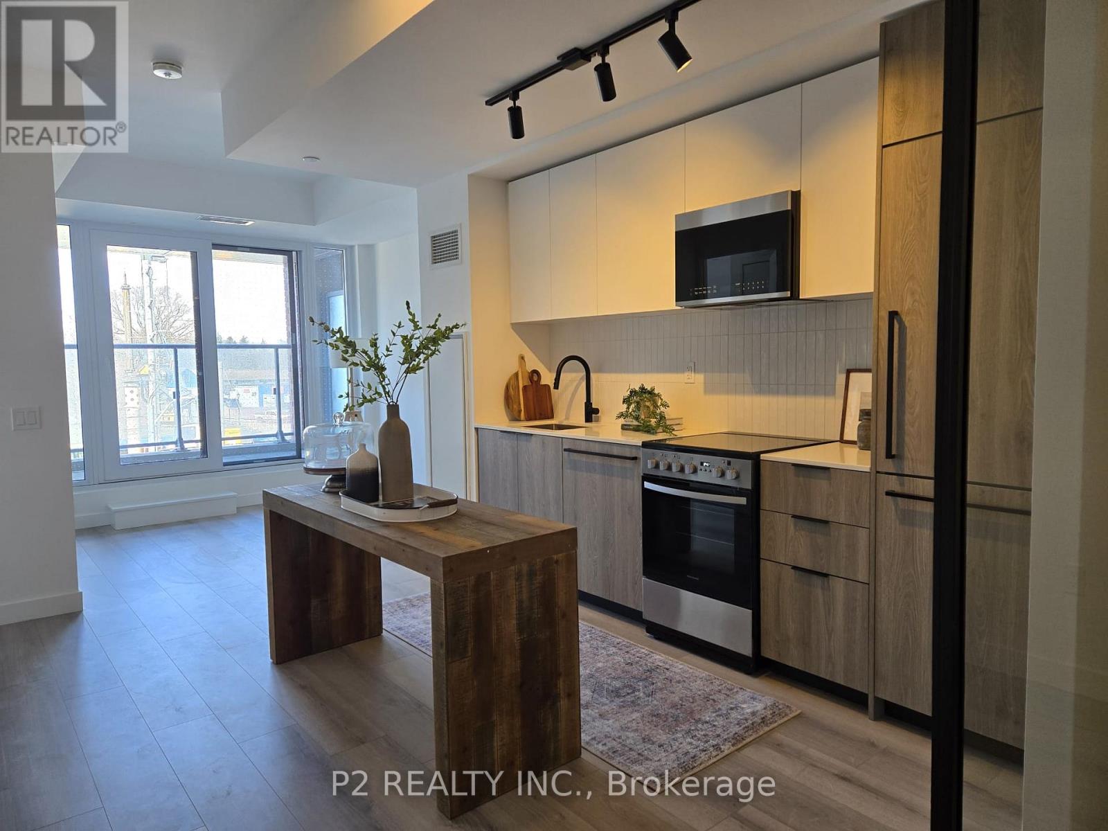 A modern kitchen with a wooden island and stainless steel appliances.
