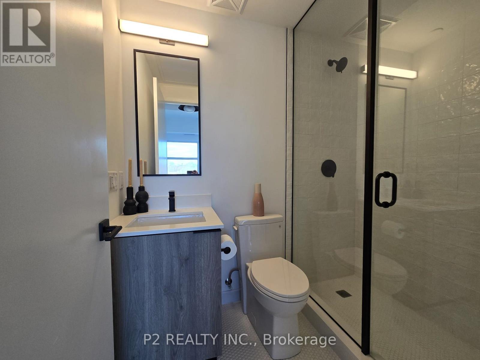 A bathroom with a toilet, sink, and mirror.