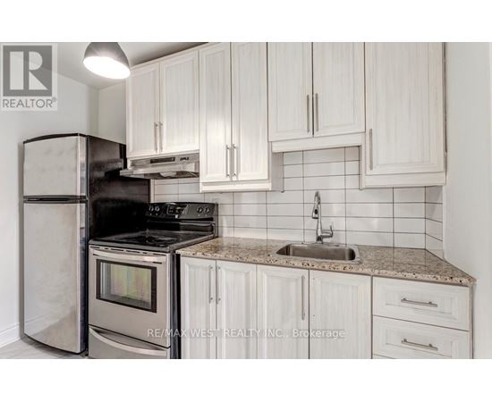 A kitchen with white cabinets and a granite countertop.