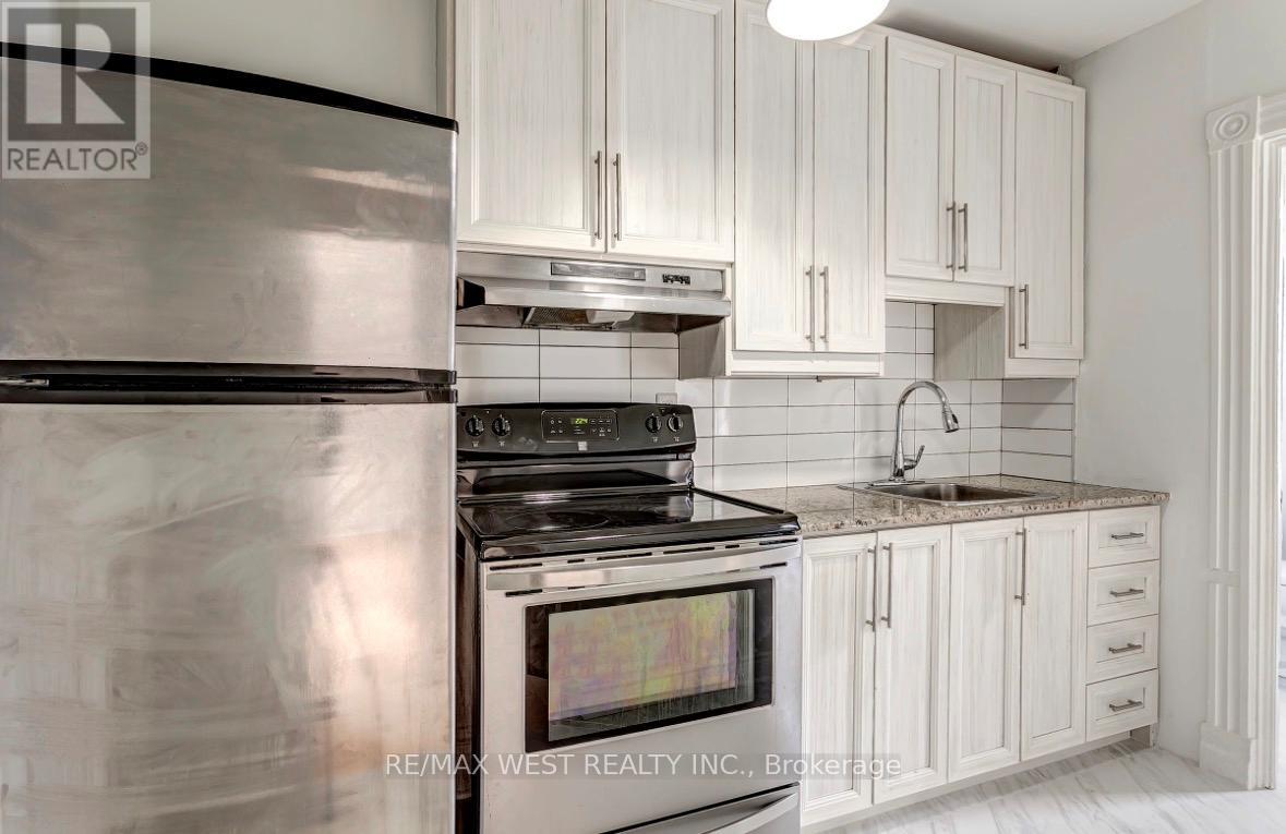 A modern kitchen with white cabinets and a stainless steel refrigerator.