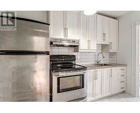 A modern kitchen with white cabinets and a stainless steel refrigerator.