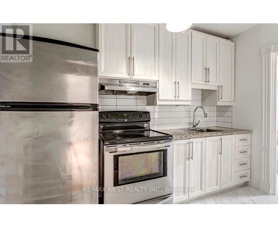 A modern kitchen with white cabinets and a stainless steel refrigerator.