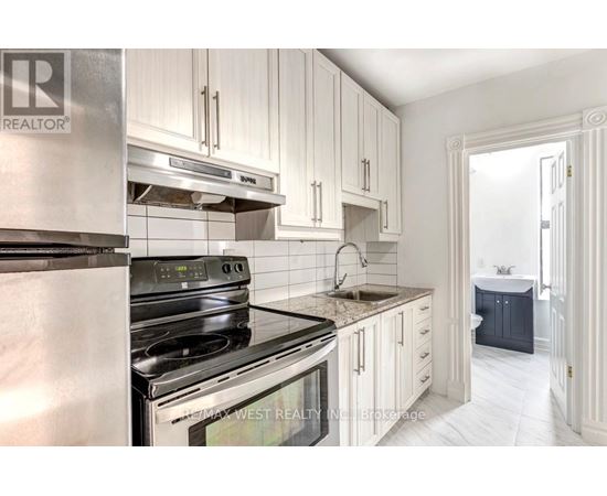 A kitchen with white cabinets and stainless steel appliances.