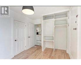 A white bedroom with a large open closet.