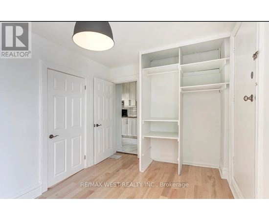 A white bedroom with a large open closet.