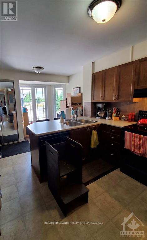 A kitchen with a sink, stove, and cabinets.