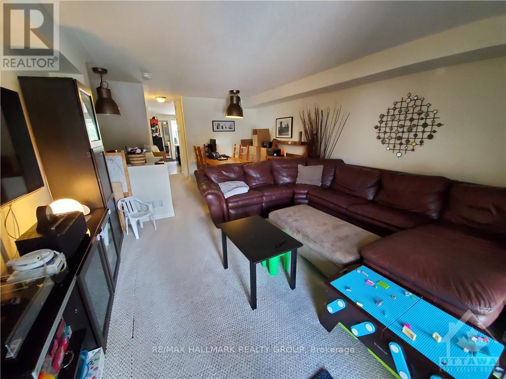A living room with a brown couch and a white chair.
