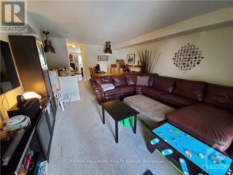 A living room with a brown couch and a white chair.