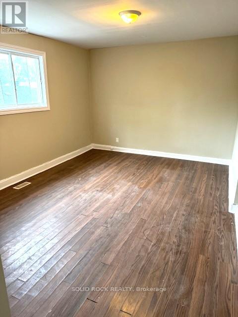 A room with wood flooring and a window.